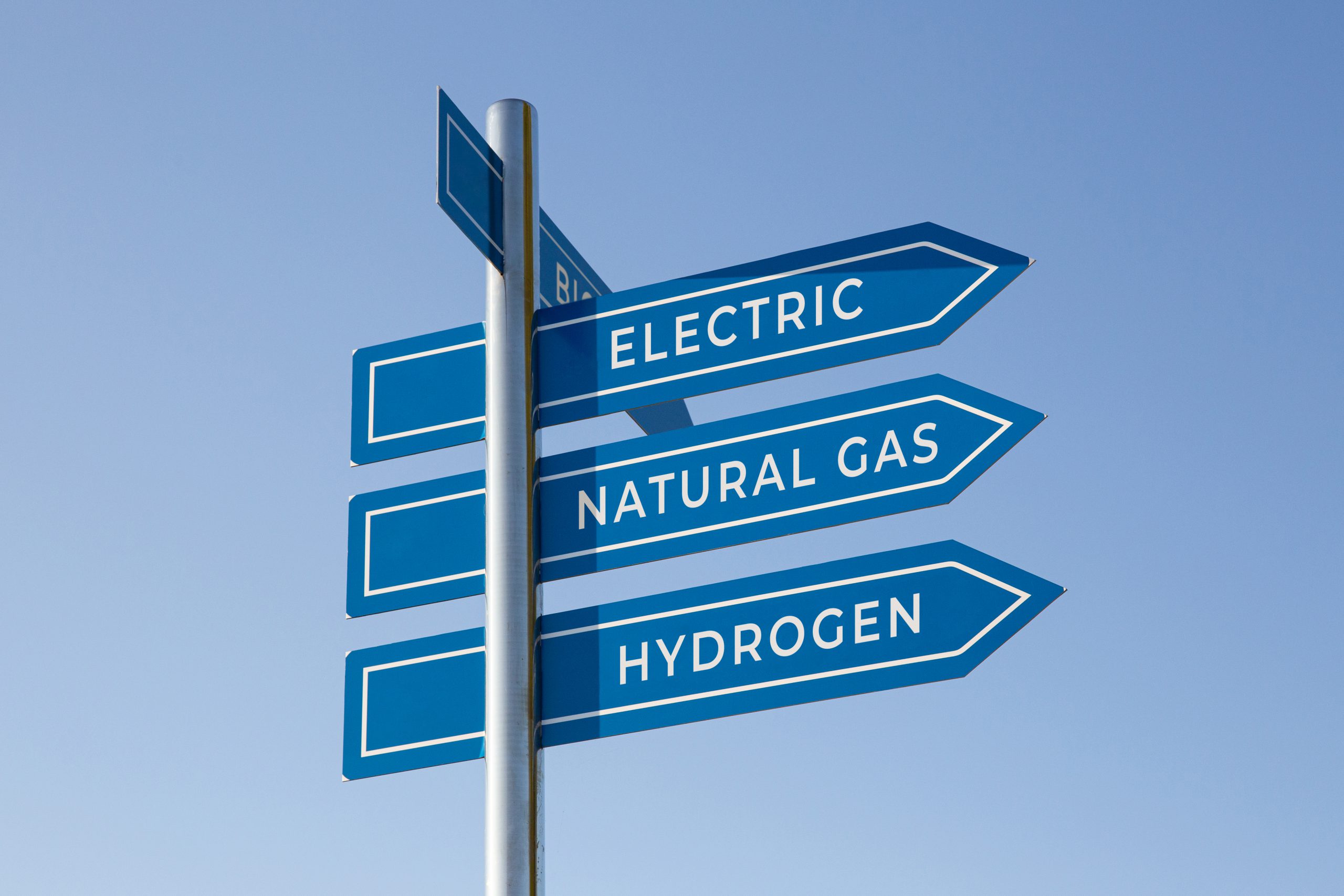 Vehicle alternative energy concept. Electric, natural gas, hydrogen words on signpost isolated on blue sky